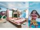 Themed ' bedroom with a bunk bed, mural, and bright decor at 7224 Oakmoss Loop, Davenport, FL 33837