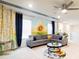 Bright bonus room featuring a sunflower mural, comfortable sectional, and decorative details at 7224 Oakmoss Loop, Davenport, FL 33837