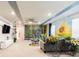 Bright bonus room featuring a sunflower mural, greenery wall, and a comfortable sectional at 7224 Oakmoss Loop, Davenport, FL 33837