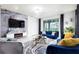 Stylish living room featuring a modern fireplace, sleek TV, and elegant blue sofas at 7224 Oakmoss Loop, Davenport, FL 33837