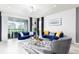 Bright living room boasts stylish blue sofas, elegant decor, and sliding glass doors at 7224 Oakmoss Loop, Davenport, FL 33837
