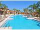 Resort style pool with palm trees, lounge chairs, and a clubhouse with ample seating areas at 7224 Oakmoss Loop, Davenport, FL 33837