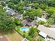 An aerial view shows a sparkling pool, fenced yard, mature trees, and surrounding neighborhood homes at 7249 Abbey Ln, Winter Park, FL 32792
