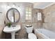 Well-lit bathroom with decorative tilework, soaker tub and pedestal sink at 7249 Abbey Ln, Winter Park, FL 32792