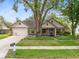 Charming single-story brick home featuring a well-manicured front yard and attached two car garage at 7249 Abbey Ln, Winter Park, FL 32792