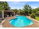 Relaxing backyard oasis showcasing a sparkling blue pool with a pebble deck, surrounded by mature landscaping at 7249 Abbey Ln, Winter Park, FL 32792