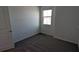 An empty bedroom features neutral tones with plush carpeting and natural light from the window at 7612 Danube Rd, Kissimmee, FL 34746