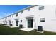 New townhome exterior featuring a sliding glass door and lawn at 7612 Danube Rd, Kissimmee, FL 34746