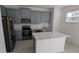 Modern kitchen with stainless steel appliances, island and gray cabinets at 7612 Danube Rd, Kissimmee, FL 34746