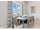 Bright dining area featuring large windows, stylish curtains, and a modern table setting at 7740 Sandy Ridge Dr # 216, Reunion, FL 34747