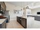 Modern kitchen featuring stainless steel appliances, quartz countertops, and views of the living room at 7740 Sandy Ridge Dr # 216, Reunion, FL 34747