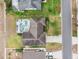 An aerial view of a property showcasing a screened pool, landscaping, roof and driveway at 7760 Indian Ridge N Trl, Kissimmee, FL 34747