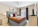 Cozy bedroom with carpet, fan, queen bed, bedside tables and lamps, a large window, and a dresser with TV at 7760 Indian Ridge N Trl, Kissimmee, FL 34747