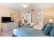 Comfortable bedroom featuring a queen bed, dresser with TV, and access to the dining room at 7760 Indian Ridge N Trl, Kissimmee, FL 34747