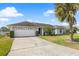 Well-maintained single Gathering home with a two car garage and a charming front yard with palm trees at 7760 Indian Ridge N Trl, Kissimmee, FL 34747