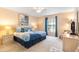 Comfortable bedroom with queen bed, ceiling fan, blue and white bedding, and natural light at 7760 Indian Ridge N Trl, Kissimmee, FL 34747