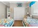 Bright bedroom featuring twin beds, a desk, a closet, and beach-themed accents at 8522 Blue Horizon Ct, Kissimmee, FL 34747