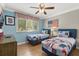 Bright bedroom with two twin beds, a ceiling fan, and a window with natural light at 8522 Blue Horizon Ct, Kissimmee, FL 34747