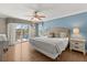 Bright bedroom with wood floors, blue accent wall, slider to the deck, and water views at 8522 Blue Horizon Ct, Kissimmee, FL 34747