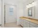 Bright bathroom featuring a tan countertop, white cabinets, and a large framed mirror at 8932 Sw 101St Cir, Ocala, FL 34481