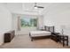 Cozy bedroom with neutral carpet, ceiling fan, and large window at 8932 Sw 101St Cir, Ocala, FL 34481