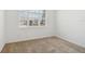 Bright empty bedroom features a window overlooking the street, as well as tan carpeting at 8932 Sw 101St Cir, Ocala, FL 34481