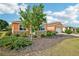 View of the front yard with a tree, shrubs and mulch, as well as the house, which is stucco with stone facade at 8932 Sw 101St Cir, Ocala, FL 34481