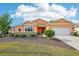 Charming single-story home featuring a well-maintained lawn, attractive landscaping, and an attached two-car garage at 8932 Sw 101St Cir, Ocala, FL 34481