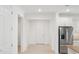 Bright hallway with white walls, neutral tile flooring, and doorways leading to other rooms in the home at 8932 Sw 101St Cir, Ocala, FL 34481