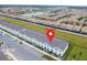 Aerial view showcasing the community's layout with townhomes, parking and pond at 8944 Sydney Ave, Kissimmee, FL 34747