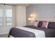 Well lit bedroom features a stylishly patterned wallpaper, modern lighting and a bed at 8944 Sydney Ave, Kissimmee, FL 34747