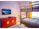 Charming bedroom features bunk beds, TV, and colorful Mickey Mouse themed cabinet at 8944 Sydney Ave, Kissimmee, FL 34747