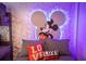 The stylish bedroom features playful Mickey Mouse wallpaper and colorful pillows at 8944 Sydney Ave, Kissimmee, FL 34747