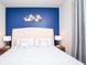 Bedroom features a modern blue accent wall with decorative art and a comfortable bed at 8944 Sydney Ave, Kissimmee, FL 34747