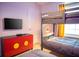 Charming bedroom features bunk beds, TV, and colorful Mickey Mouse themed cabinet at 8944 Sydney Ave, Kissimmee, FL 34747