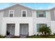 Charming townhome featuring light gray siding, a light-blue front door and matching shutters at 8944 Sydney Ave, Kissimmee, FL 34747