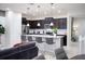 Modern kitchen featuring dark cabinetry, stainless steel appliances, granite countertops, and an island with seating at 8944 Sydney Ave, Kissimmee, FL 34747