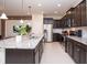 Modern kitchen featuring dark cabinetry, stainless steel appliances, granite countertops, and an island with seating at 8944 Sydney Ave, Kissimmee, FL 34747