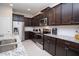 Stylish kitchen with dark cabinets, stainless steel appliances, granite countertops, and a subway tile backsplash at 8944 Sydney Ave, Kissimmee, FL 34747