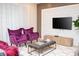 Bright living room featuring velvet chairs, a textured wall, and a sleek entertainment center at 8944 Sydney Ave, Kissimmee, FL 34747