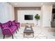 Modern living room featuring decorative wall panel, purple armchairs, and contemporary furniture at 8944 Sydney Ave, Kissimmee, FL 34747