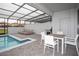 Outdoor patio with dining table, lounge chairs, and a screened-in private pool at 8944 Sydney Ave, Kissimmee, FL 34747