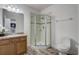 Bathroom features a glass shower, wood cabinet and granite countertops, providing a modern aesthetic at 10231 Lenox St, Clermont, FL 34711