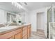 Bathroom showcasing double sinks, wood cabinets, a glass door shower, and modern fixtures at 10231 Lenox St, Clermont, FL 34711
