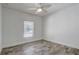 Bedroom featuring wood-look floors, a ceiling fan, and natural light from a window at 10231 Lenox St, Clermont, FL 34711