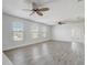 Bonus room showcasing wood-look floors, bright windows, ceiling fans, and natural light at 10231 Lenox St, Clermont, FL 34711