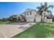 Charming two-story home showcasing a three-car garage, manicured lawn and paver driveway at 10231 Lenox St, Clermont, FL 34711
