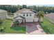 Stunning two-story home featuring a three-car garage, brick paver driveway and beautifully landscaped front yard at 10231 Lenox St, Clermont, FL 34711