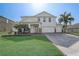 Beautifully landscaped two-story home with a three-car garage and a brick paved driveway at 10231 Lenox St, Clermont, FL 34711