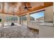 Screened-in patio with an outdoor kitchen, ceiling fans, and stone flooring for luxury outdoor living at 10231 Lenox St, Clermont, FL 34711